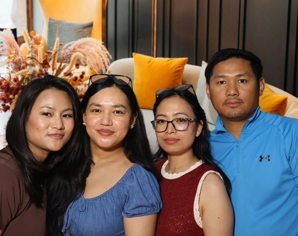 Four friends posing together in a lounge at a celebration