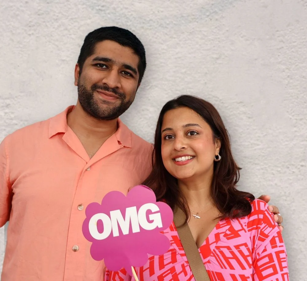 A couple holding an OMG prop at the photo booth